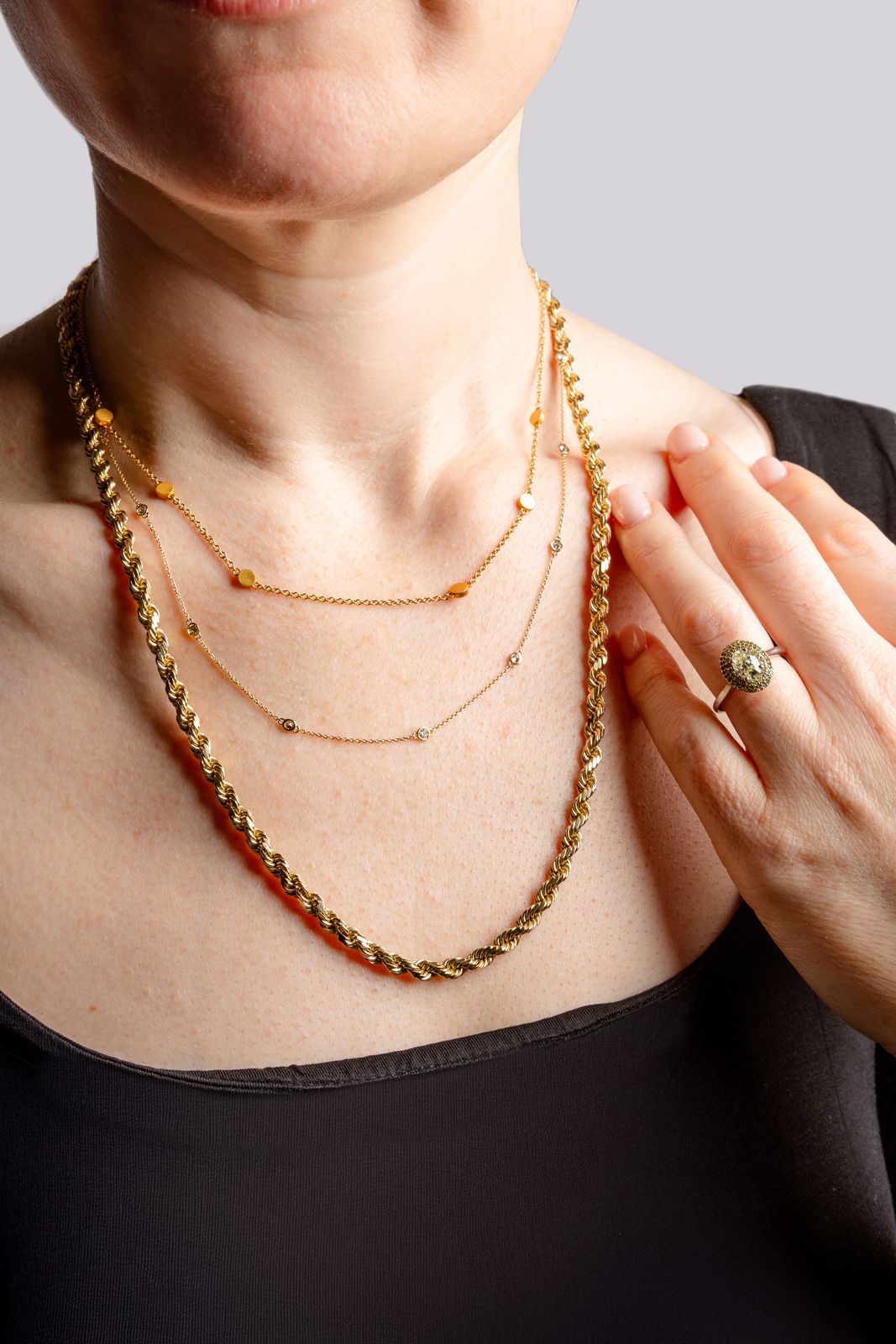 Layered gold necklaces worn during a private consultation